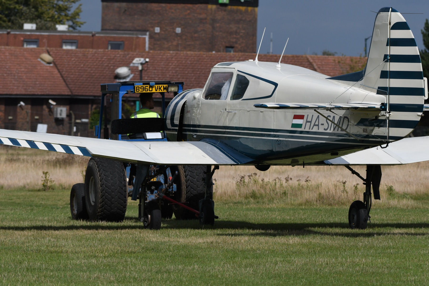 An aircraft towed across the grass past the control tower at Rochester Airport