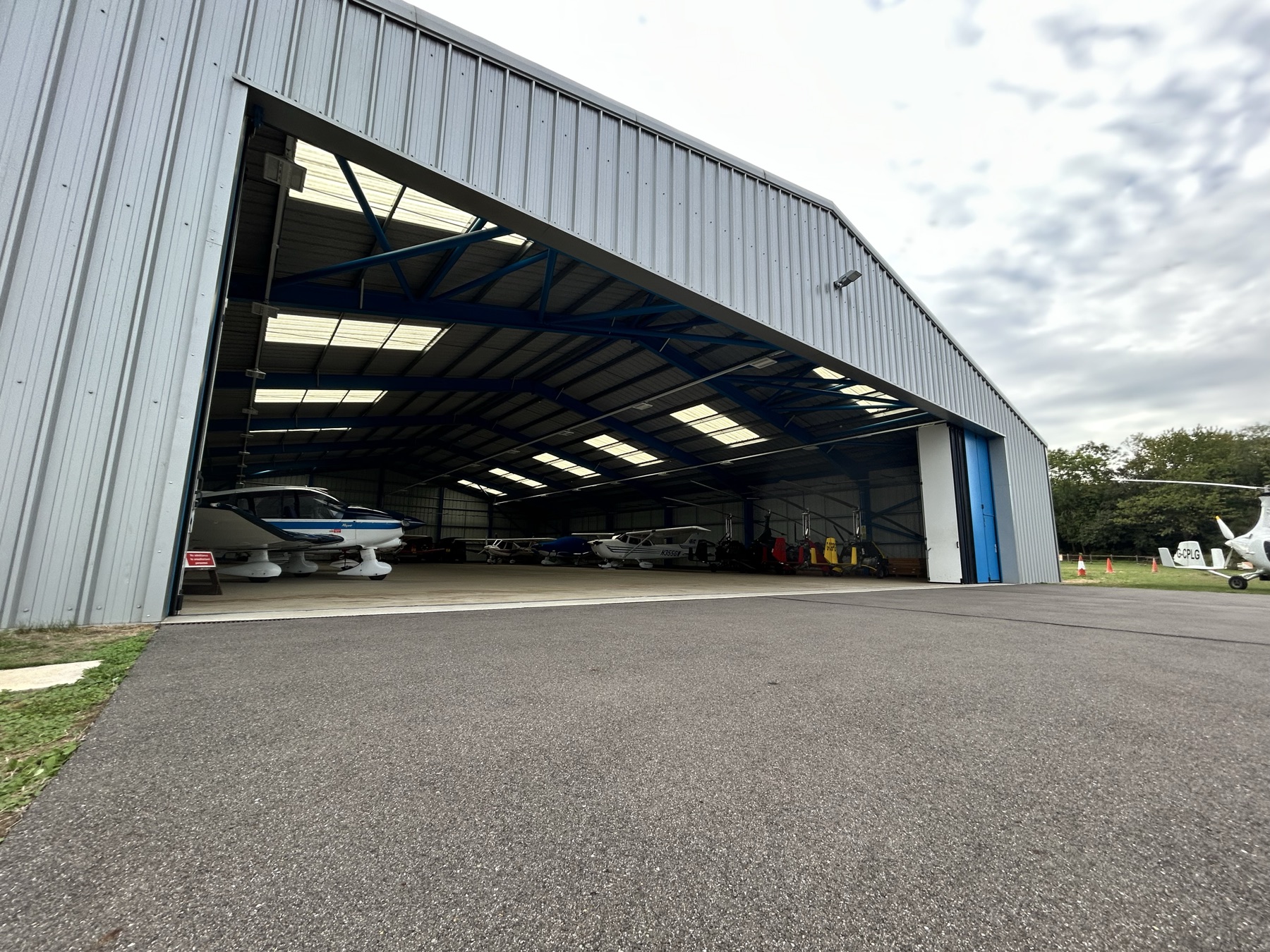 Inside the hangar at Rochester Airport, light aircraft under the roof lights